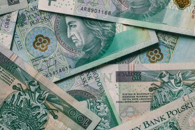Rozrzucone banknoty w kolorze zielonym o nominale 100 zł