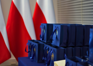 Blue gift bags with gold CBA inscriptions. Polish flags in the background.