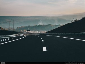 A photo of a highway. A foggy landscape in the background.