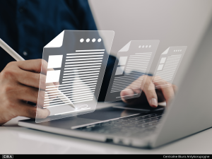 A picture of a laptop with a close-up of a man&#039;s hands and a hologram of documents above the laptop