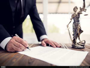 signature on the document, judge's scales in the background