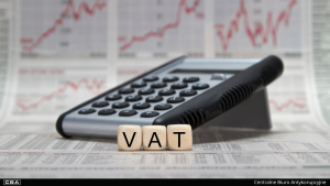 calculator and cubes with the word VAT written on them, documents in the background