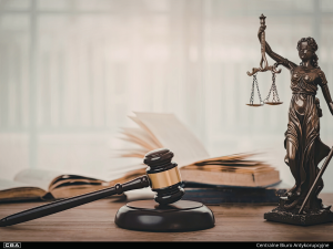 Judge's gavel and scales of justice on the table, open books in the background.