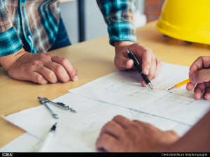 Two people over a table with construction plans.