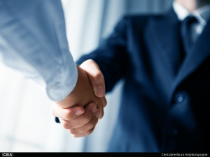 A close-up of two men shaking hands.